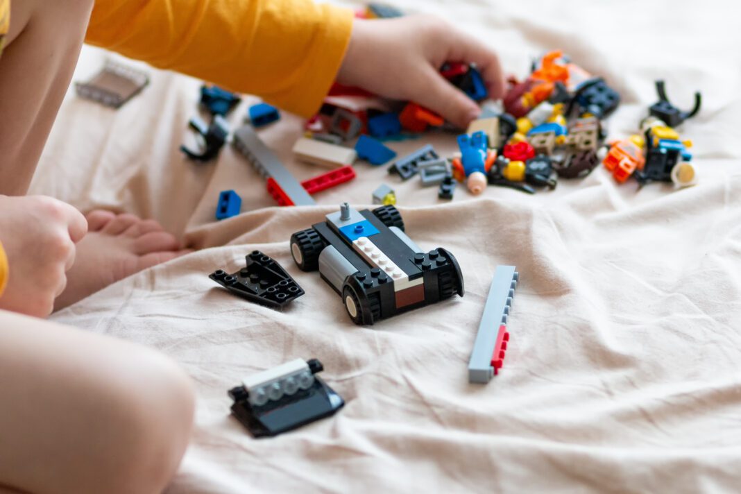 The child assembles a car from the constructor
