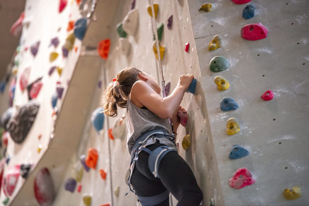 Teenage girl climbing on climbing wall