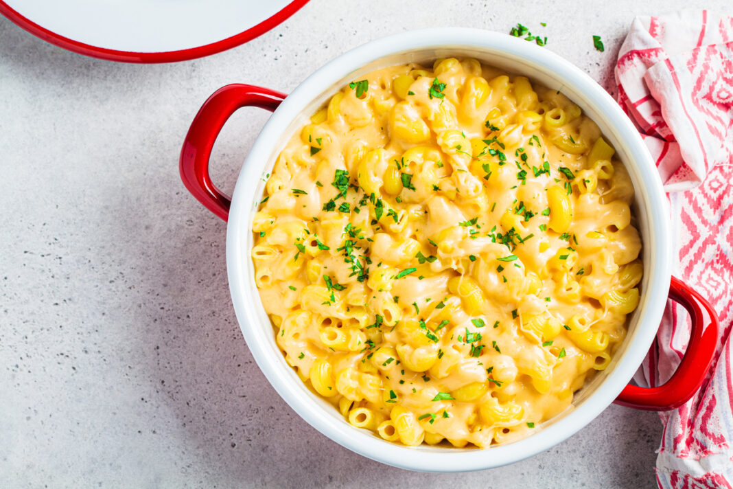 Mac and cheese in red pot. Traditional American food.