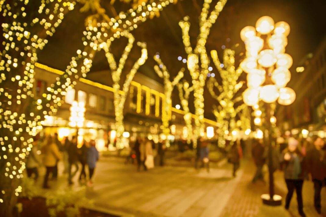 Christmas lights and people walking around on the street