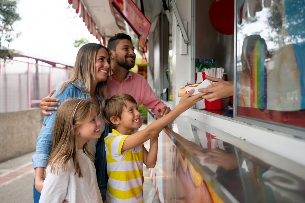 Happy family buying food at an amusement park